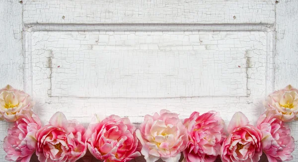 Flowers on a paneled vintage door — Stock Photo, Image