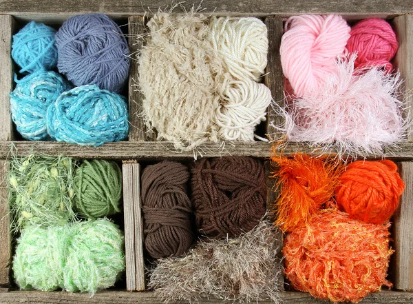 Many colorful yarns in wooden box — Stock Photo, Image
