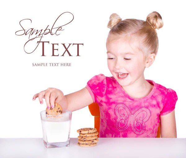 Cute dziewczynka dunking cookie w mleku — Zdjęcie stockowe