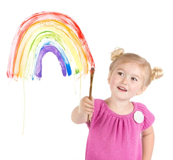 Маленькая девочка рисует радугу на окне — стоковое фото