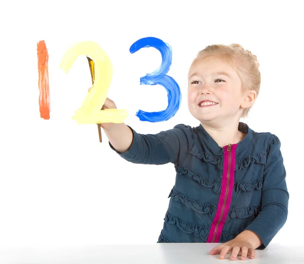 Little girl painting numbers on a window — Stock Photo, Image