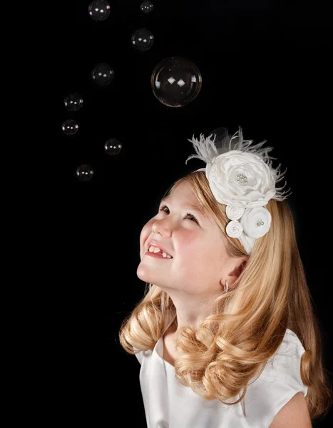 Chica vestida de blanco mirando a las burbujas — Foto de Stock