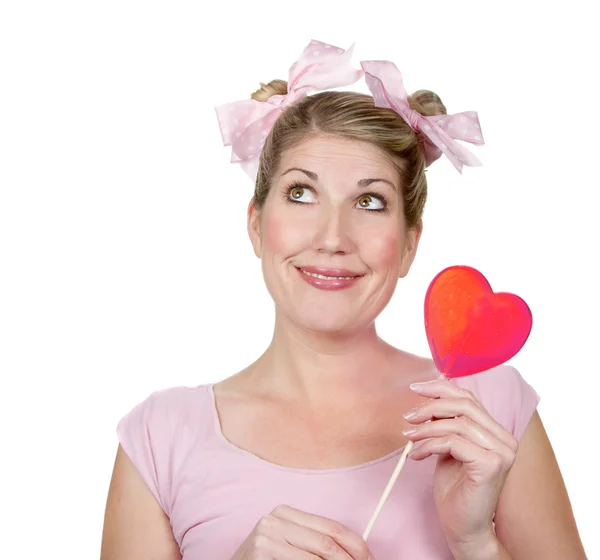 A silly woman looking up holding a red heart — Stock Photo, Image