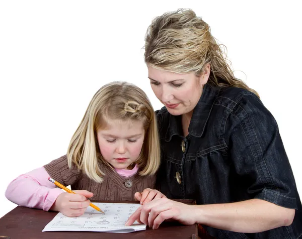 老师或妈妈帮助女孩与她的家庭作业 — 图库照片