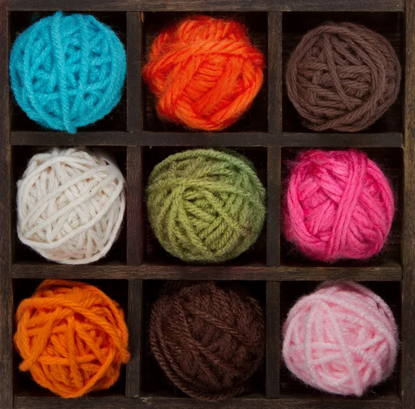 Nine colorful balls of yarn in printers box — Stock Photo, Image