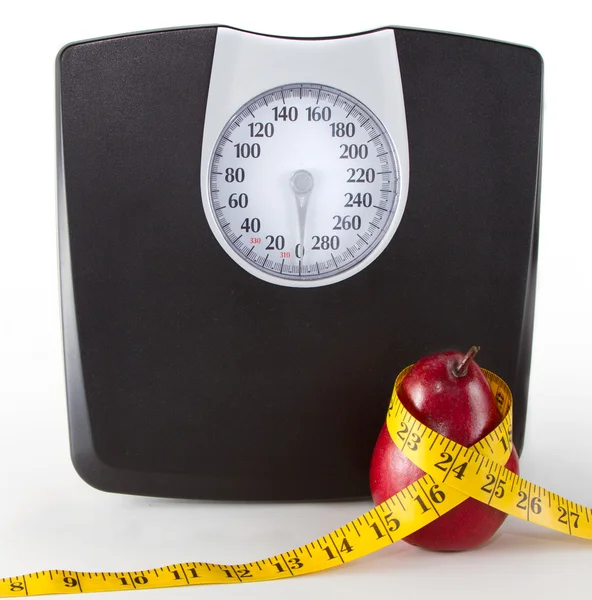 Закрыть весы и яблоко / грушу с измерительной лентой — стоковое фото
