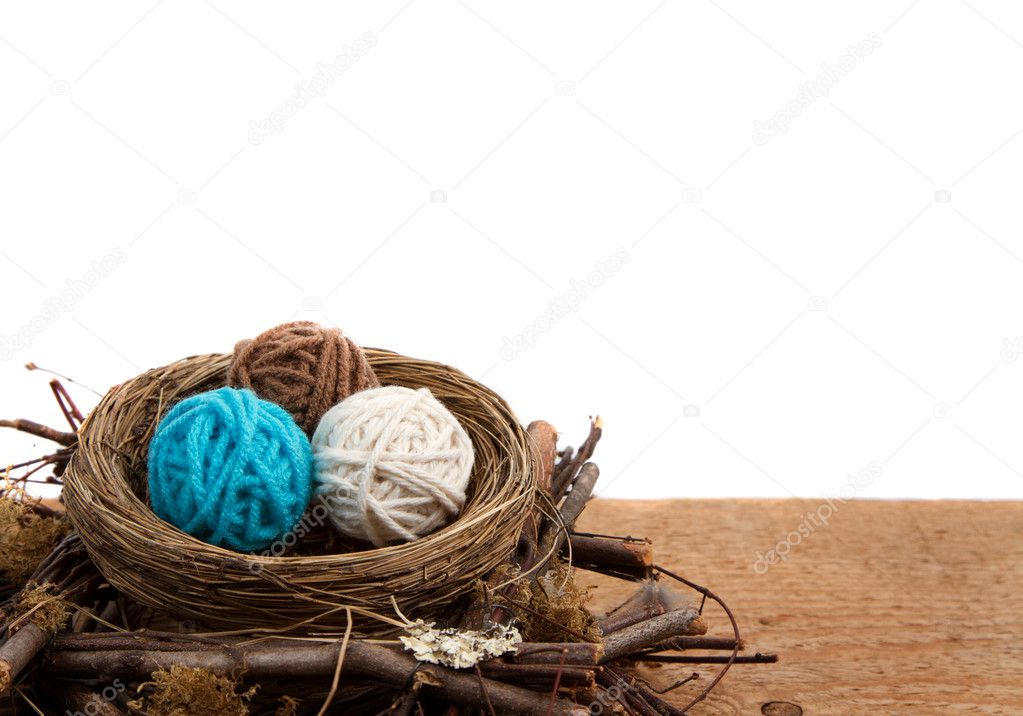Balls of yarn in a nest, white background