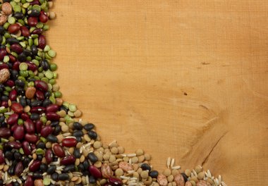 Assorted beans lentils and rice on a wood background clipart