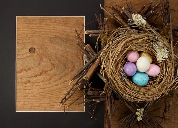 Ostereierbonbons im Nest mit Rahmen — Stockfoto