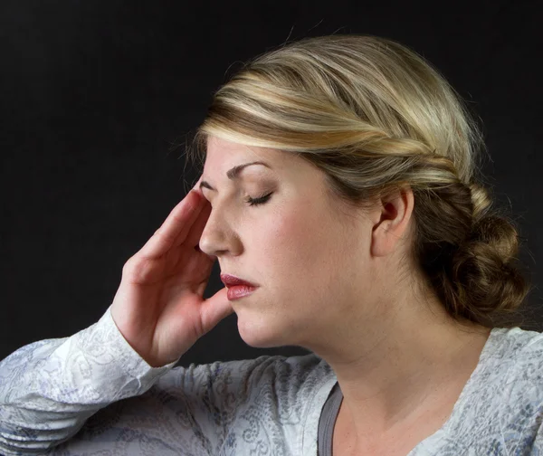 Una mujer con dolor de cabeza —  Fotos de Stock