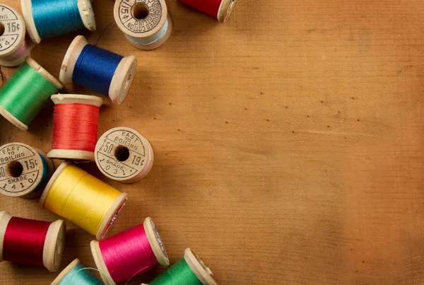 Antique spools of thread on a wooden background — Stock Photo, Image