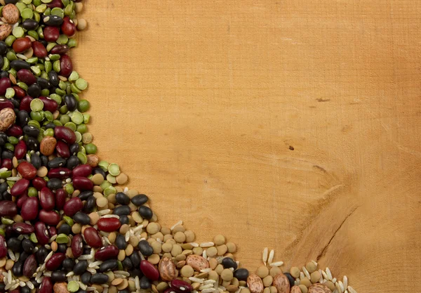 Verschiedene Bohnen Linsen und Reis auf Holz Hintergrund — Stockfoto