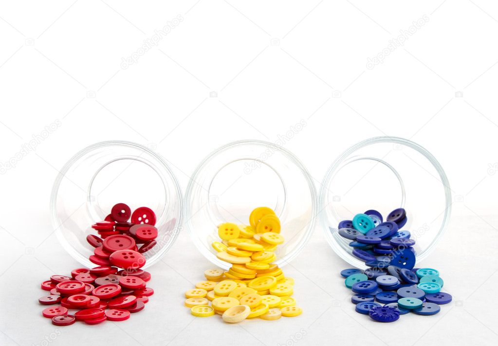 Sewing buttons spilling from jars