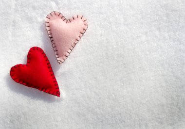 Two stitched hearts on snow clipart