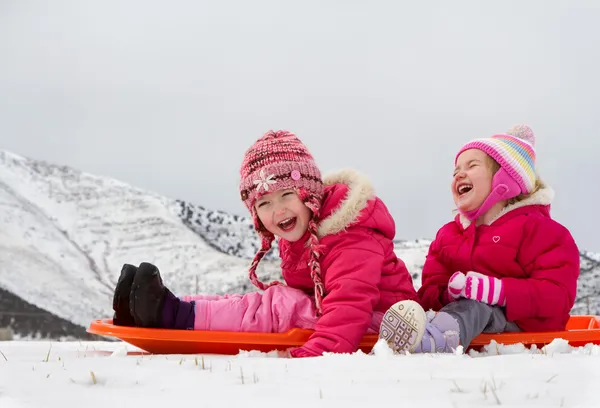 Two laughing kids sledding — Stock Photo, Image