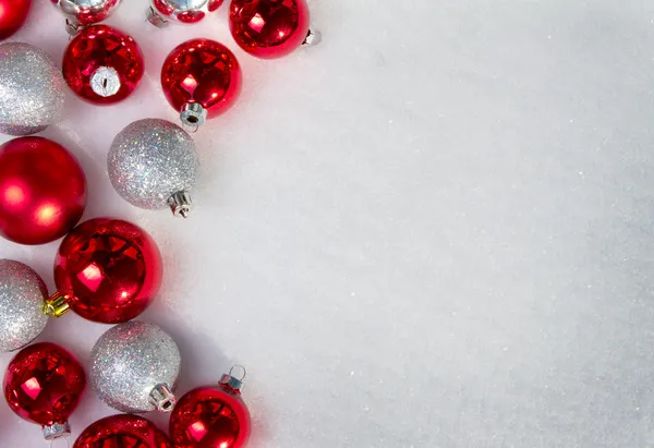 Many Christmas ornaments in the snow — Stock Photo, Image