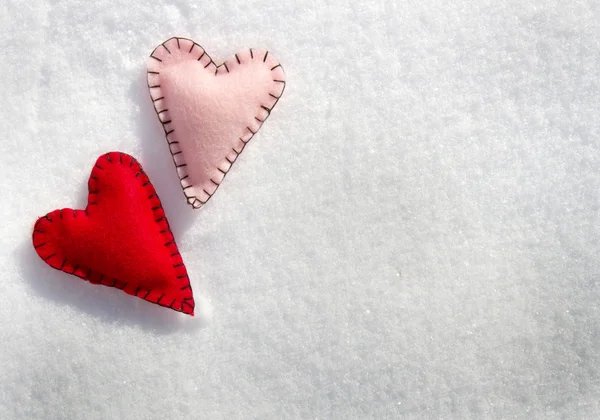 Dos corazones cosidos en la nieve — Foto de Stock
