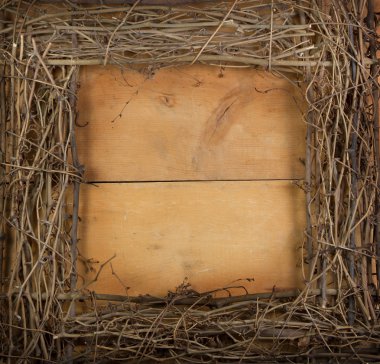 A square grapevine wreath on a wooden background clipart