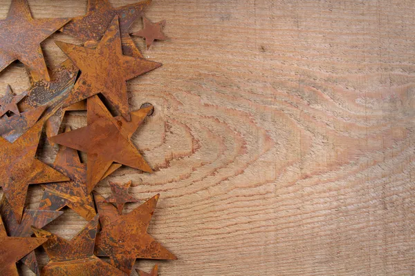 Estrelas enferrujadas em um fundo de madeira — Fotografia de Stock