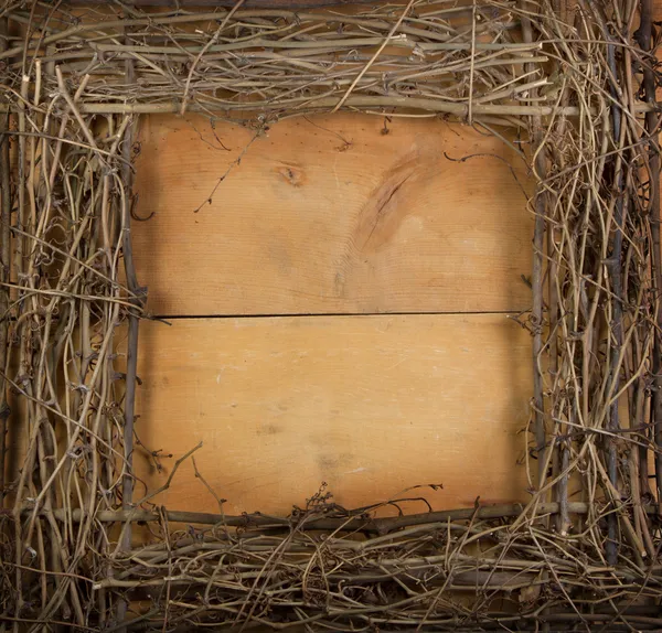 A négyzet alakú grapevine koszorú a fából készült háttér — Stock Fotó