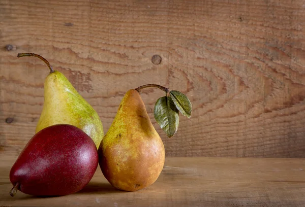 在一块木板上的三个梨 — 图库照片