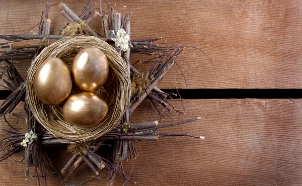 Три золоті яйця в гнізді — стокове фото