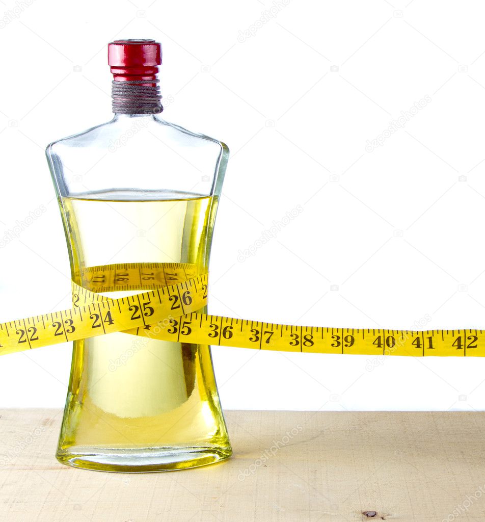A measuring tape around a bottle of olive oil