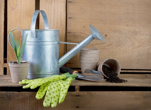 Watering can and gardening tools on wooden crates — Stock Photo, Image