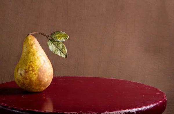 Pear on a rustic stool — Stock Photo, Image