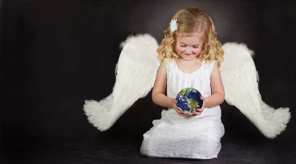 天使が彼女の手で世界を握る — ストック写真