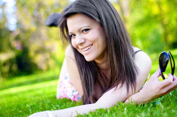 Hot brunette laying on green grass — Stock Photo, Image