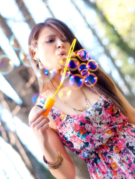 Portrait of a girl blowing bubbles in the wind — Stock Photo, Image