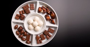 Small chocolate flavors isolated on dark background