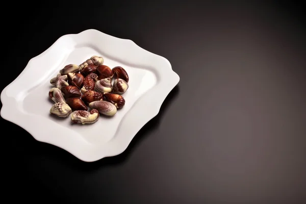 Bitar av schweizisk choklad snäckskal på vit, fancy tallrik — Stockfoto