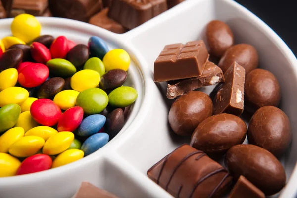 Bunte Schokoladenbonbons mit zufälligen Schokoladenstücken — Stockfoto