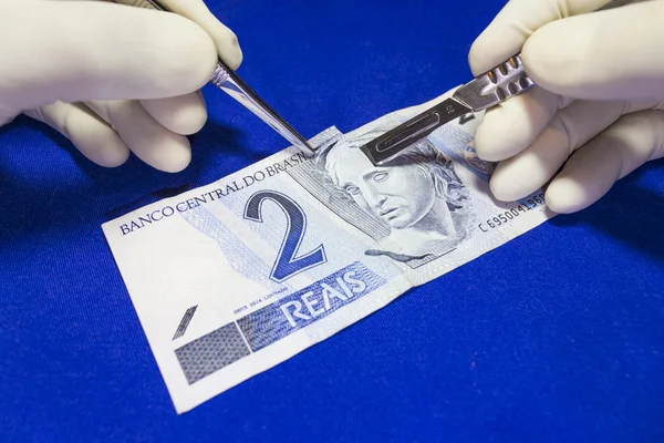 Μια χειρουργική κομμένα σε μια σημείωση Βραζιλίας νόμισμα Royalty Free Εικόνες Αρχείου