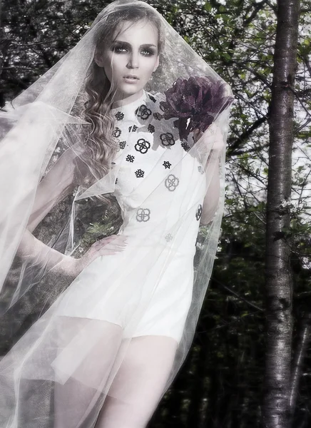 Fiancée sensuelle en robe de mariée posant sur fond de nature — Photo
