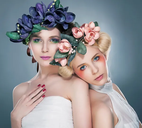 Zwei anmutige Frauen - schöne Brünette und hübsche Blondine posiert im Studio Stockbild