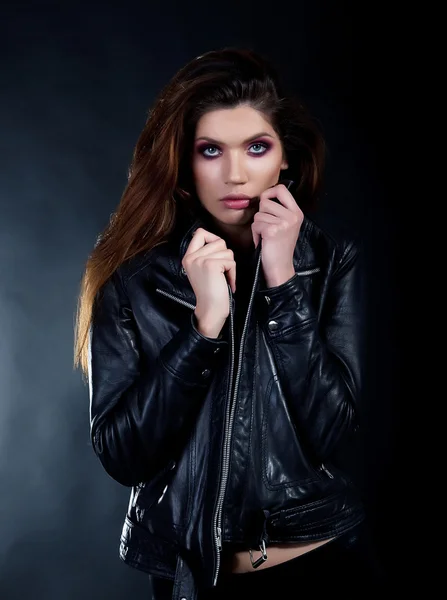 Verbazend jong meisje brunette in zwart lederen jas poseren — Stockfoto