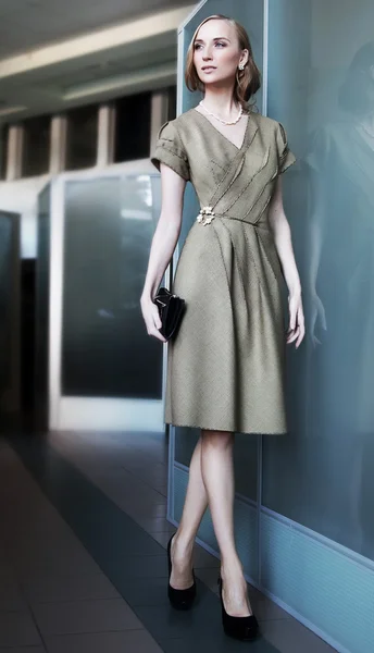 Beautiful slim businesswoman fashion model walking in office space — Stock Photo, Image