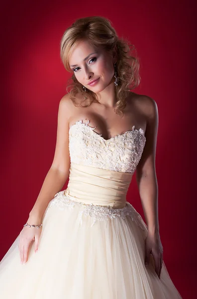 Snoubenka v bílých svatebních šatech na červeném pozadí zblízka — Stock fotografie