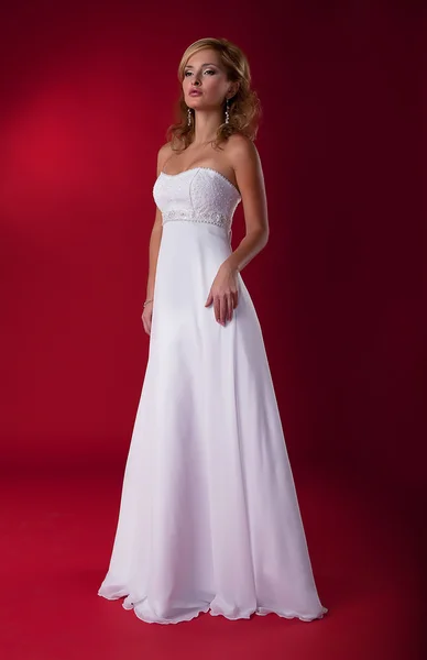 Mooie bruid blond in bruiloft jurk die zich voordeed op podium poseren — Stockfoto
