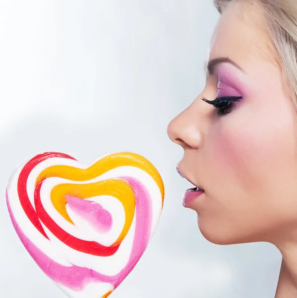 Όμορφη νεαρή κοπέλα γλυκό με ζάχαρη γλειφιτζούρι ως μια καρδιά — Φωτογραφία Αρχείου