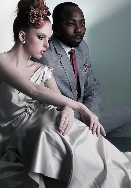 Dois modelos de moda sentado - homem preto e mulher ruiva — Fotografia de Stock