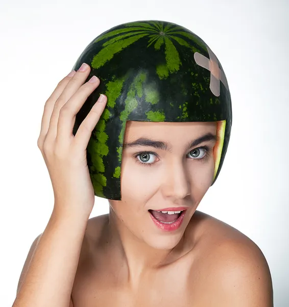 Elegante chica feliz joven con melón verde fresco como un sombrero duro — Foto de Stock