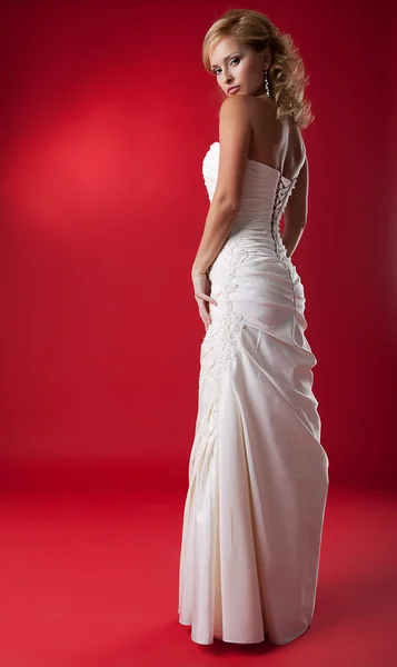 Preciosa modelo de moda rubia en vestido de novia blanco en el podio rojo —  Fotos de Stock