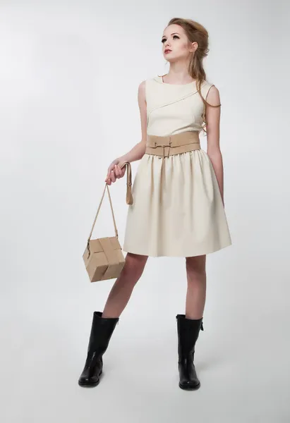 Bella ragazza in abito moderno con borsa sul podio — Foto Stock