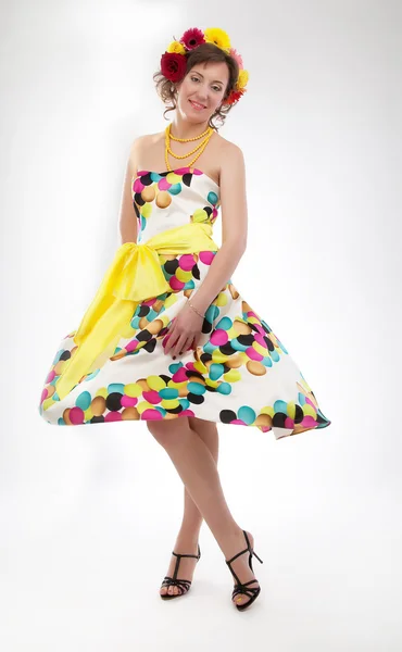 Graciösa glada unga flickan i färgglada fjädrar klänningen poserar i studio — Stockfoto