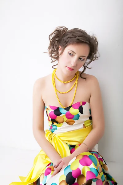 Kunstporträt einer jungen hübschen Frau in buntem hellen Kleid — Stockfoto