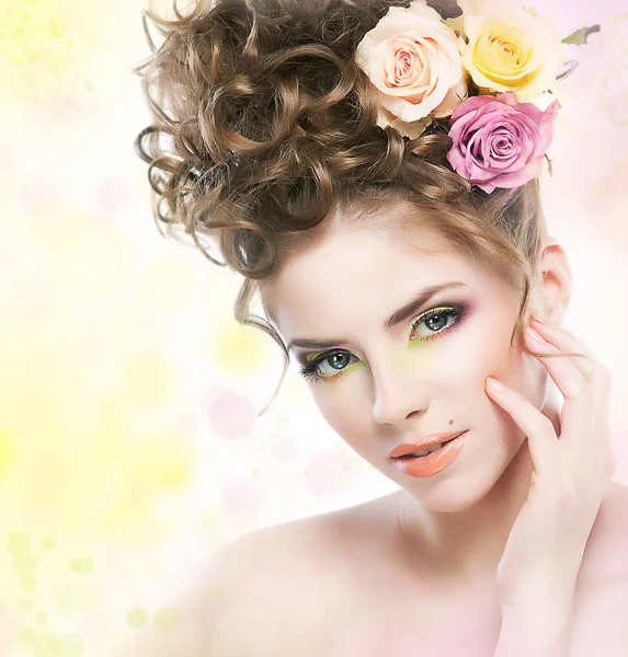 Vacker ung flicka med blommor röra hennes vackra ansikte — Stockfoto